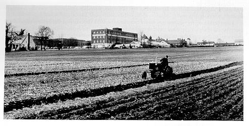 old black and white photograph of a tractor in field